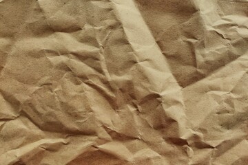 Crumpled brown kraft paper texture background with realistic wrinkles for sustainable packaging design and vintage aesthetic.