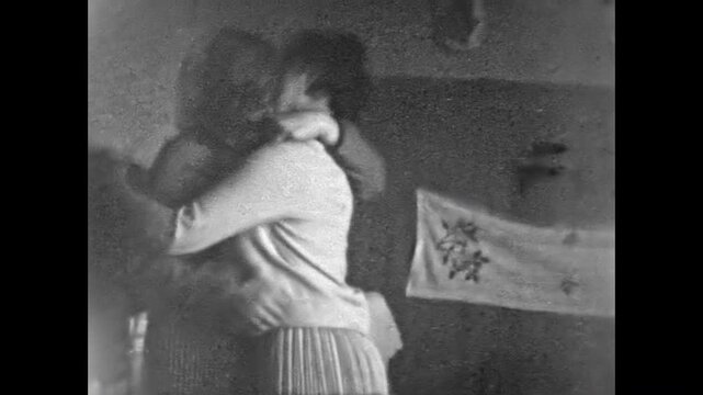Two adult women passionately kissing on lips at home. Happy lesbian love in 1970s. Female couple together in retro romance. Intimate between lgbtq loving in room. Archival old film. Vintage archive