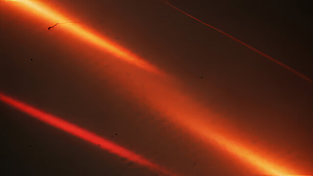 Abstract Fiery Orange and Red Light Streaks with Subtle Dust Motes on Dark Background