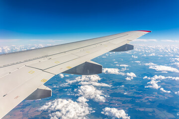 Obraz premium View from the airplane window at a beautiful cloudy sky and the airplane wing