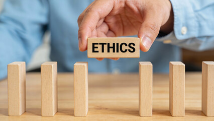 Concept for business ethics marketing showing hand placing wooden block to build trust integrity and moral responsibility in corporate strategy