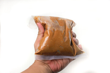 hand holding, peanut butter in plastic, isolated on white background