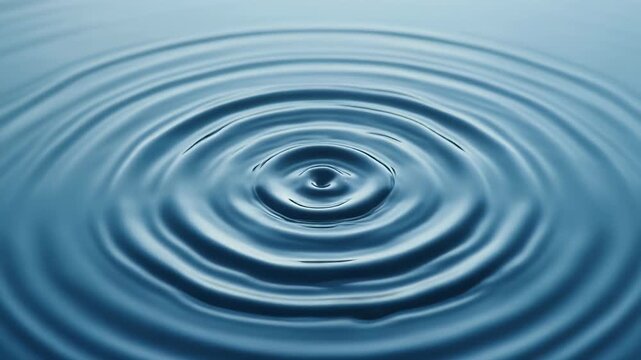A serene close-up view of a single droplet's impact creating symmetrical, calming ripples on a liquid surface