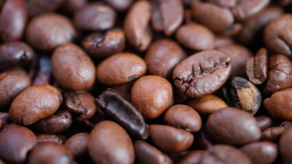 Obraz premium Coffee bean closeup, Close perspective on glazed roasted coffee beans detailed image, Highresolution macro photograph capturing glossy surface of roasted coffee beans in detail