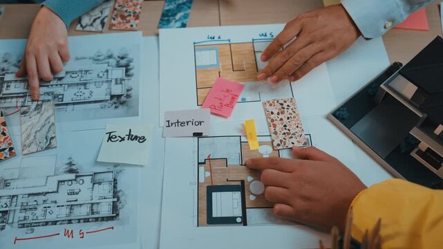 Engaging scene of hands collaborating on interior design projects, featuring colorful materials and detailed sketches on a workspace table to inspire creativity and innovation. SACTR