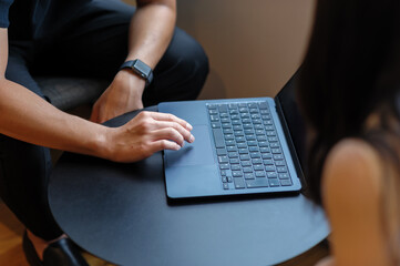 ノートパソコンを操作する人物の手元とデジタルワークのイメージ