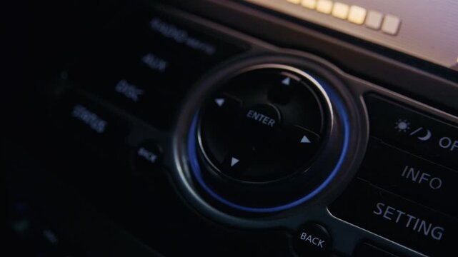 Close up of a person adjusting the multimedia system settings on a modern vehicle's dashboard