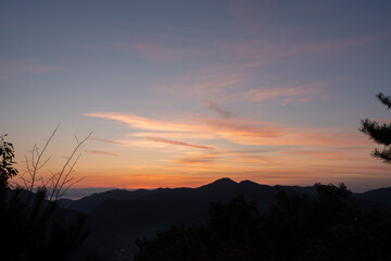 Fototapeta premium 朝焼けの空と山々のシルエット