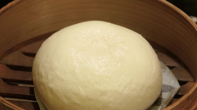 アツアツの湯気が出てる蒸篭の動画。まんまるな肉まんのクローズアップ。