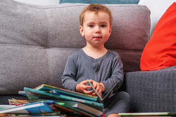 Toddler smiling with open book, representing childhood wonder and the beginnings of educational exploration.