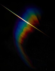 Bright, linear light refracts into a spectrum against a dark backdrop