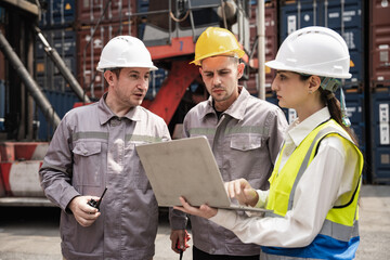 Engineer and worker team working in logistic terminal of container cargo, Diverse construction team in safety gear outdoors