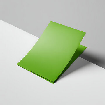 A vibrant green notepad rests on a light grey surface casting a shadow