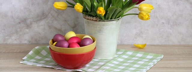 Easter eggs in bowls with blooming tulips