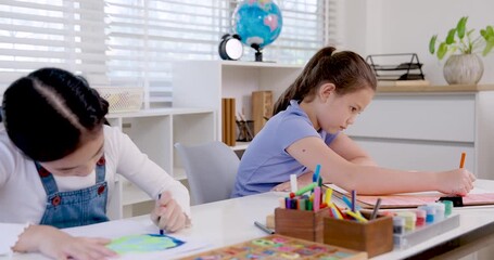 asian girl preteen student concentrating on coloring drawing while caucasian girl beside working quietly assignment during slowmotion classroom scene education teamwork learning art creativity study - Powered by Adobe