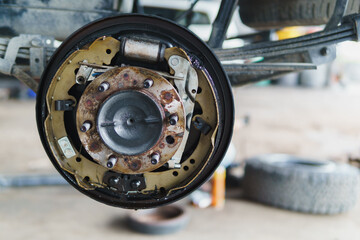 This concept relates to maintaining a car braking system. The photograph shows the orange area of ​​the rear brake assembly with oil stains from a leaking seal, causing oil buildup on the brake pads