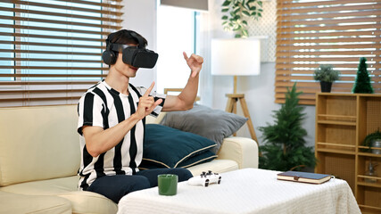 Excite white man playing online game with vr glasses at home