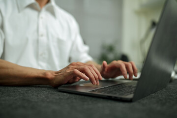 Closeup hand typing on laptop keyboard, businessman working on laptop