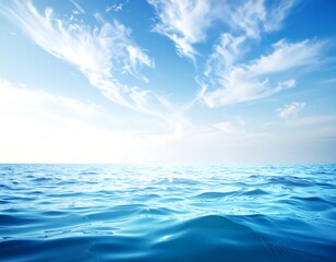 Vast ocean with blue waves under a bright blue sky with wispy clouds