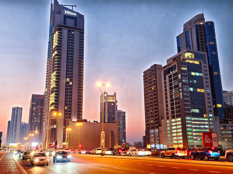 Manama, Bahrain - September 28, 2025: Busy urban street in Manama, Bahrain during sunset with tall buildings and traffic congestion