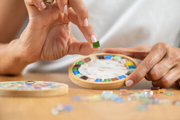 Adding decorative pieces, assembling mosaic coasters in a home workspace. Emphasizes accuracy, artistic structure, and step by step craft flow.