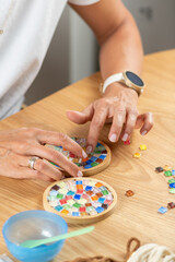Crafting coasters at home using simple materials. Highlights careful hand movement, design focus, and steady creative hobby work.