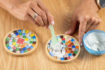 Adding a protective topcoat to handmade coasters as part of her craft routine. Emphasizes controlled application, material care, and decorative clarity.