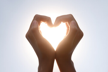 Fototapeta premium Hands Making Heart Shape Silhouette in Sunlight