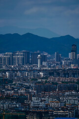 Obraz premium Modern City Skyline with Mountain Backdrop - Urban Landscape View