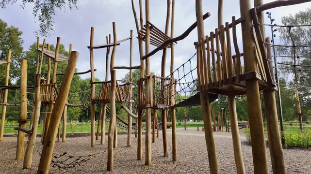 Outdoor children adventure park with wooden climbing frames and rope elements