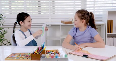 asian girl preteen student holding drawing on notebook smiling proudly during classroom art lesson creativity learning achievement encouragement elementary education childhood study inspiration moment