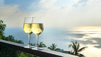 Obraz premium Two glasses of white wine ocean view at sunset, Island Ko Tao, Surat Thani, Thailand, Southeast Asia.