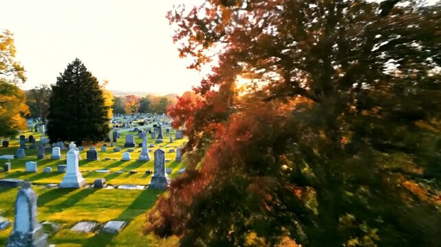Aerial view of a cemetery with trees and tombstones at sunset.