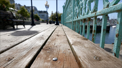 Wooden boardwalk with turquoise railing by the sea.