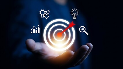 Glowing bullseye target with arrow at center, surrounded by business icons above a cupped hand