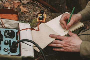 Russian Soviet Infantry Red Army Soldier In World War II using Russian Soviet Portable Radio Transceiver In Trench Entrenchment In Spring Autumn Forest. 4K. Headphones And Telegraph Key. Close Up