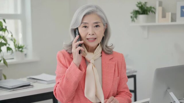 A professional woman on the phone in an office setting.