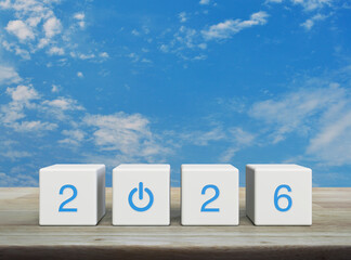 2026 start up business flat icon on white block cubes on wooden table over blue sky with white clouds, Happy new year 2026 success concept