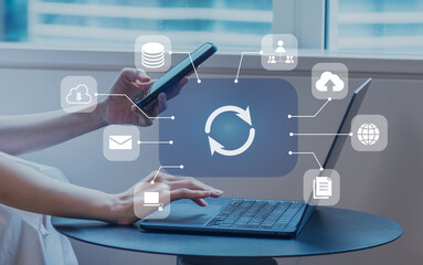 ビジネスシーン、クラウドでのデータ連携、DX、デジタルネットワークイメージ 　スマートフォンとノートパソコンを操作する女性 © Metro Hopper