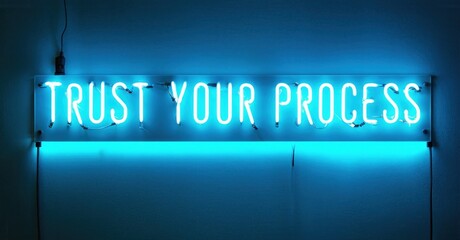 Bright neon sign displays motivational phrase. Blue glow illuminates surrounding wall, creating modern aesthetic. Simple, impactful message.