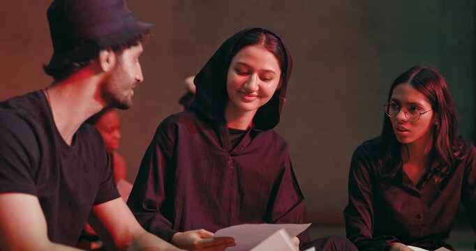 Indian young adult gen z male man female group hold script paper read new story line learn drama at studio teen girl boy team talk speak share new plan idea enjoy day spend break time hall stage place