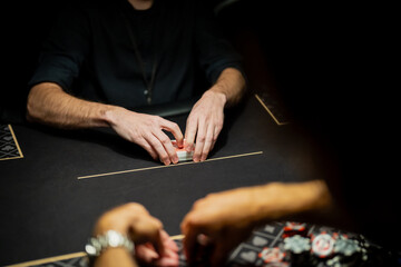 Live casino poker table scene with dealer hands organizing card deck and players waiting to bet, showing controlled procedures in gaming industry