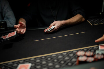 Live poker table action showing dealer hand flicking playing card across felt surface while players wait, illustrating professional casino dealing mechanics