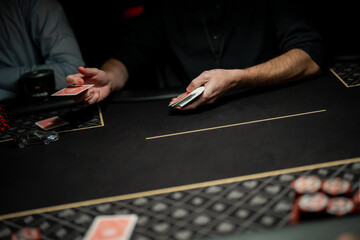 Casino poker dealer releasing a single playing card mid air toward betting area, capturing precise card motion and regulated dealing practice in live gaming