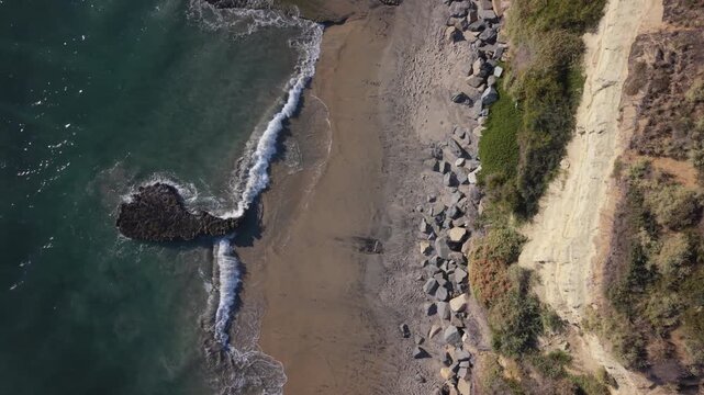 Top down drone shot of Swamis Beach in Encinitas, California. Drone ascending. Beautiful and peaceful beach scene.