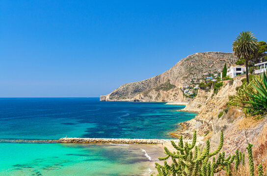 Aerial panoramic view coastline Costa Blanca coast slope in Calpe town and Morro de Toix cliffs Sierra de Bernia mountain, Calpe bay Mediterranean Sea in sunny summer day, Alicante province, Spain