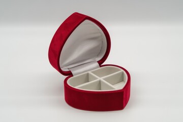 Open red heart shaped jewelry box with white compartments inside velvet