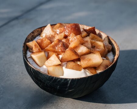 Diced fruit and creamy yogurt in a natural coconut bowl