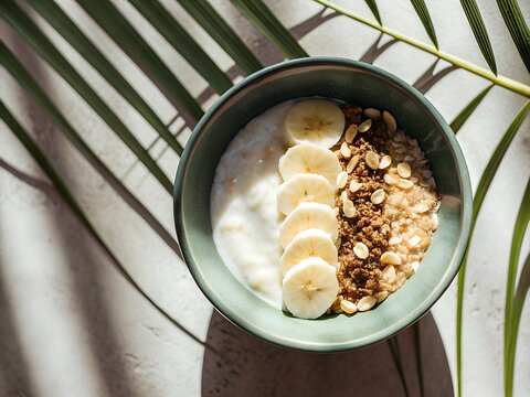Healthy yogurt bowl with banana slices and granola in natural light