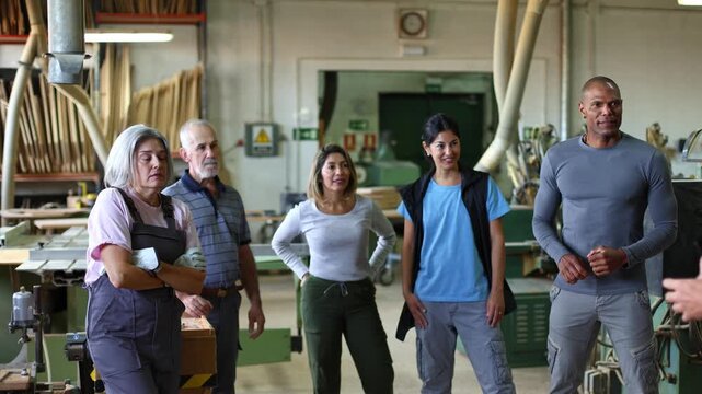 Carpentry team listening to manager's instructions in workshop